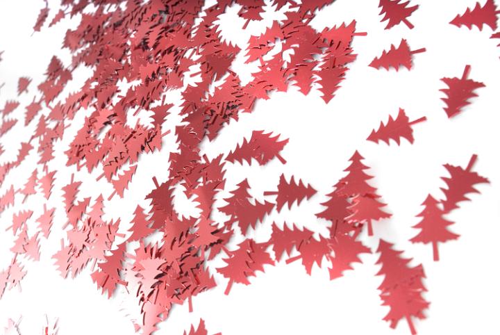 A background image of red metallic christmas tree shapes