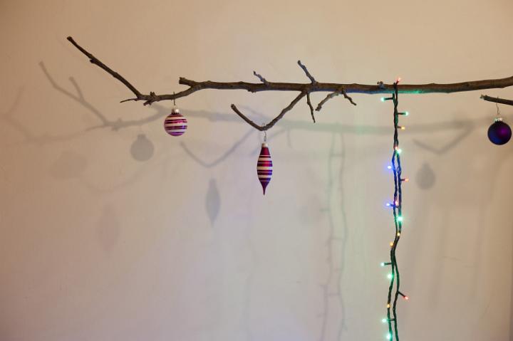Christmas tree balls and garland hanging on leafless branch. Concept. White background