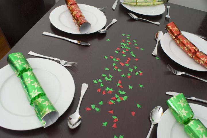 a dining table decorated with christmas glitter and set for a festive meal