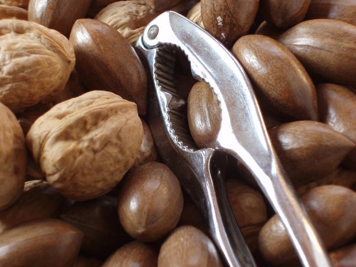 a bowl of nuts and a metal nut cracker