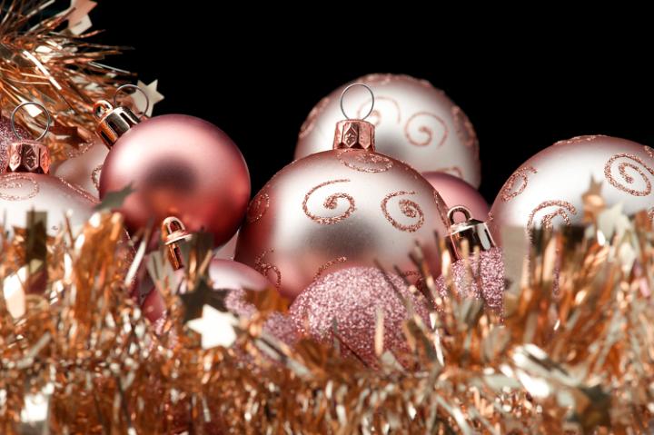 a background image with golden copper coloured christmas baubles and tinsel