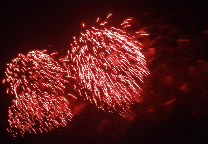 bright red fireworks sparkling in the night sky