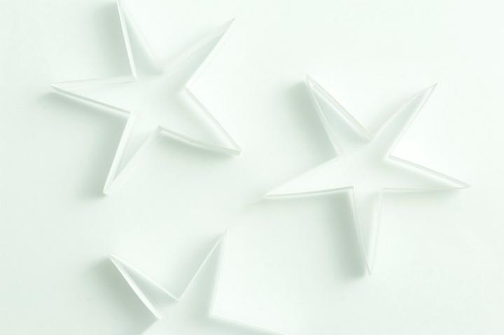 Background of delicate white stars on a white studio backdrop for any festive occasion including Christmas , anniversary or wedding