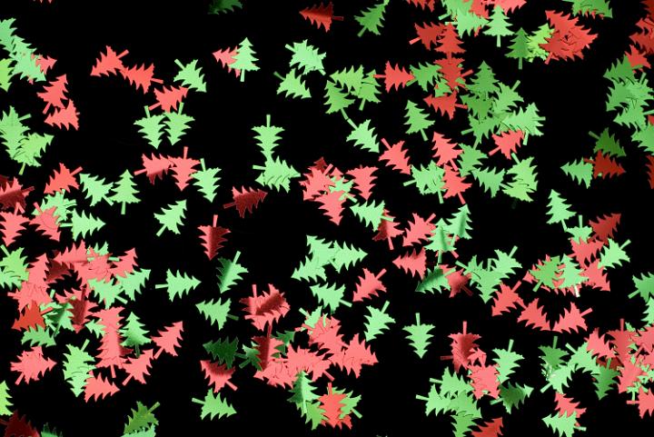 colourful metallic christmas tree shaped confetti on a black backdrop