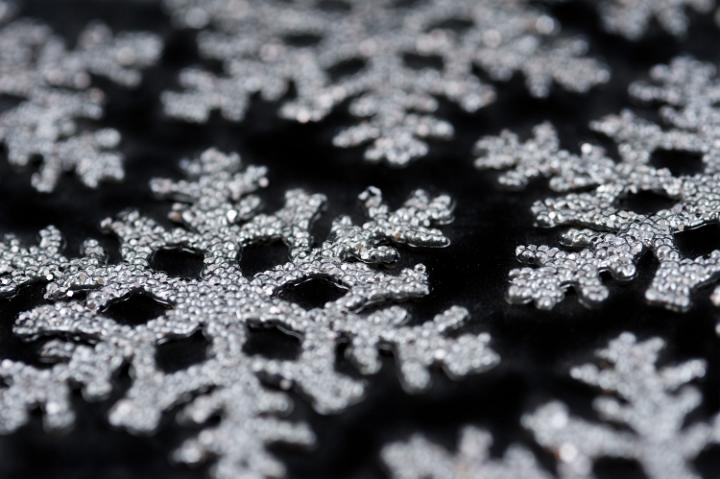 christmas snowflake shaped ornaments on a black background