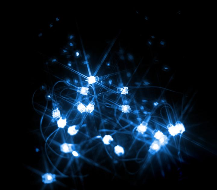 Cluster of multiple blue and white lights over dark background for Christmas or winter festival theme
