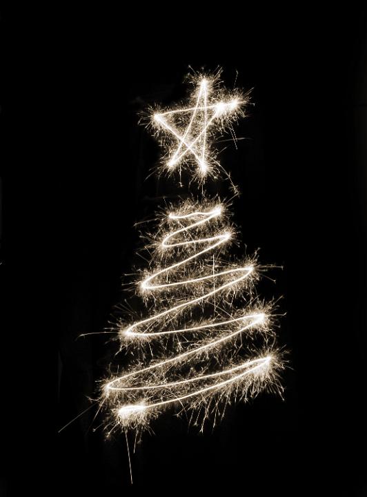 A white christmas tree symbol drawn in sparkler trails