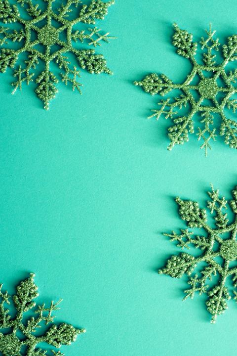 Green background with Christmas glitter snowflakes and copy space for your seasonal holiday greeting