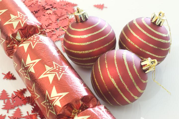 a selection of red coloured christmas baubles on a white background
