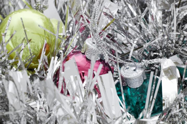 a bright silver background featuring tinsel and christmas ornaments