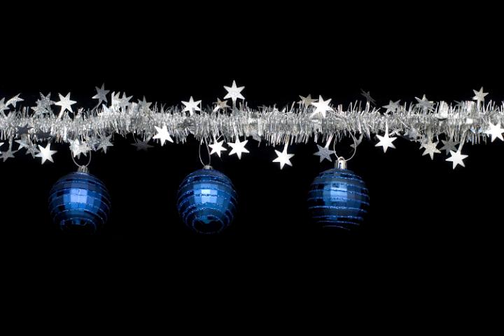 a line of christmas tinsel and blue festive ornaments make a useful border component for a christmas theme design
