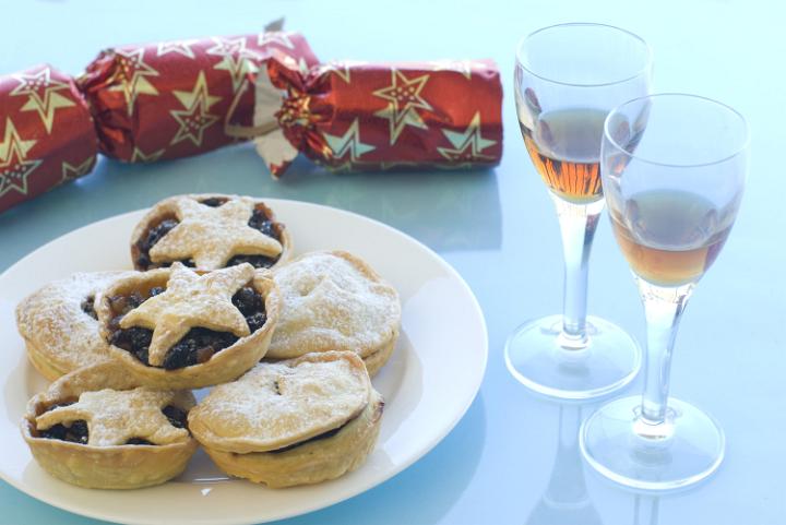 a plate of christmas mincemeat pies and with of sherry and a pulled christmas cracker