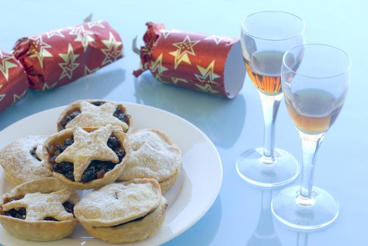 a plate of christmas mincemeat pies and glasses of sherry