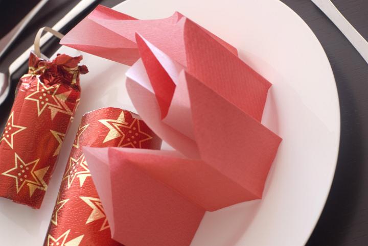 a pulled red christmas cracker and paper party hat