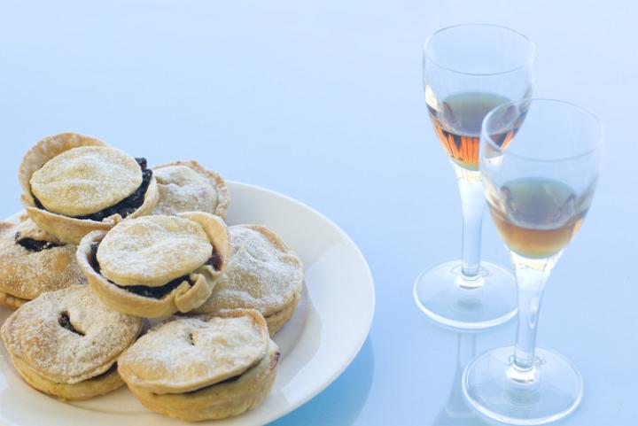a plate of christmas mince pies and glasses of sherry - traditional british christmas treat