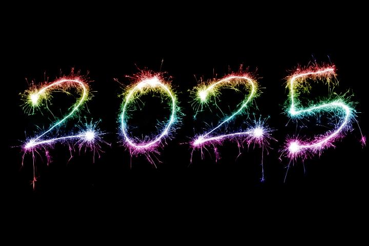 Rainbow coloured sparkling fireworks for the new year holiday 2025 over black backdrop