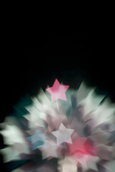 a defocused image of fireworks created with a star shaped gobo
