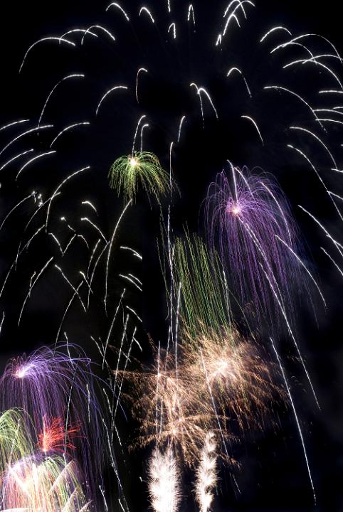 a spectacular newyears eve firework celebration purple green and white lights up the sky