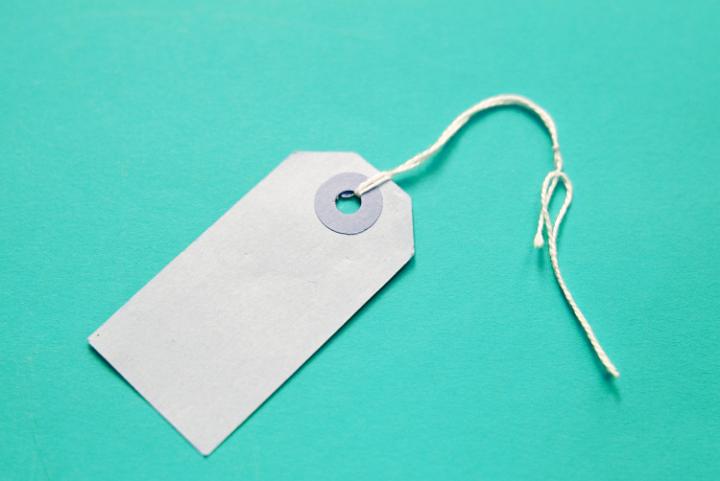 a plain white undecorated gift label on a turquoise backdrop