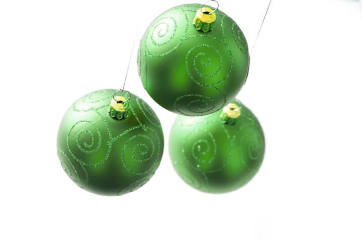 Three green Christmas balls hanging against of white background. Isolated