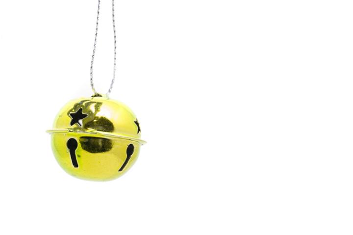 Single gold jingle bell isolated on a white background with copyspace for your Christmas message