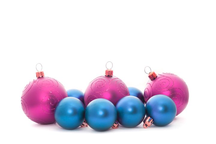 Arrangement of pink and blue decorative Christmas baubles in a row with natural shadow and copyspace for your text