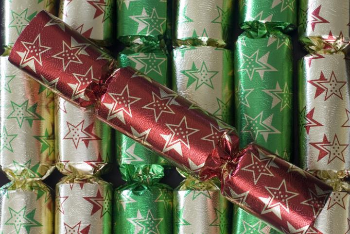 a background of christmas crackers with a single red christmas cracker on top