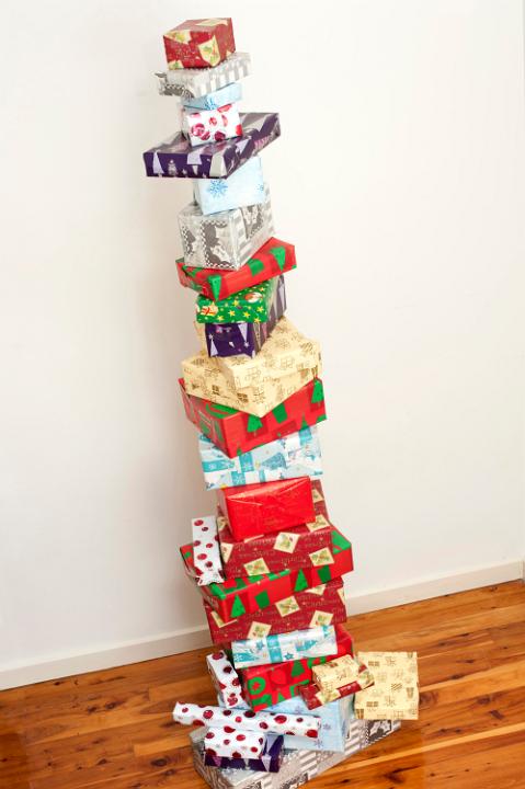 Stacked tower of colourful Christmas gifts neatly balanced one on top of the other in their pretty traditional patterned paper for a unique Xmas decoration in the home