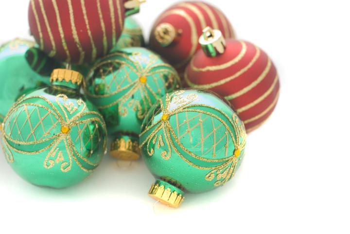 a pile of red and green christmas tree ornaments on a clean white background