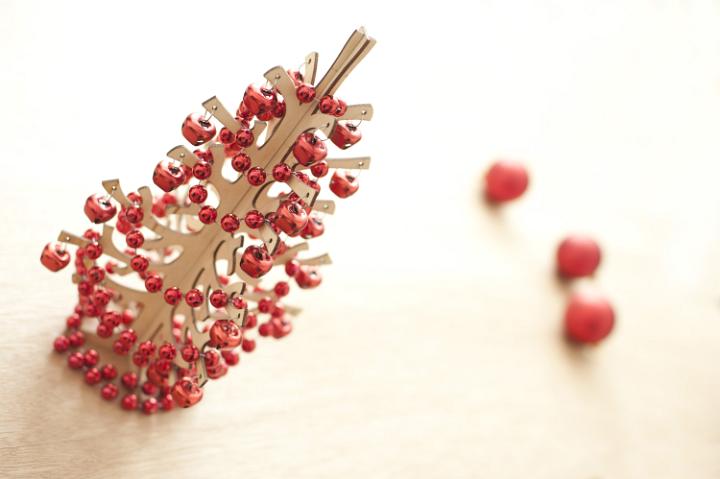 small decorative wooden Christmas tree decorated with red balls and beads