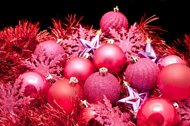 an arrangemnt of red cooured christmas decroations, baubles, tree ornaments and tinsel