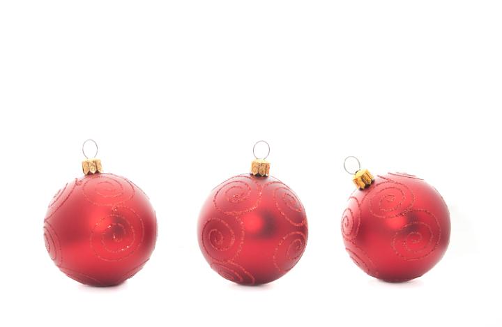 Three red Christmas baubles on a white background with copyspace