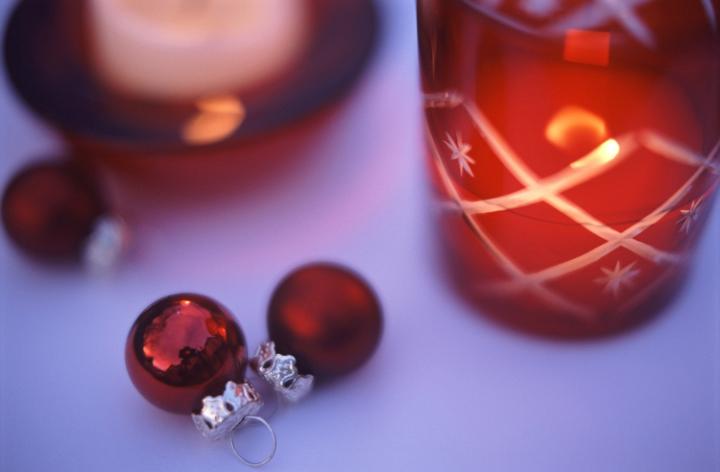 an arrangemet of red christmas decorations and a candle