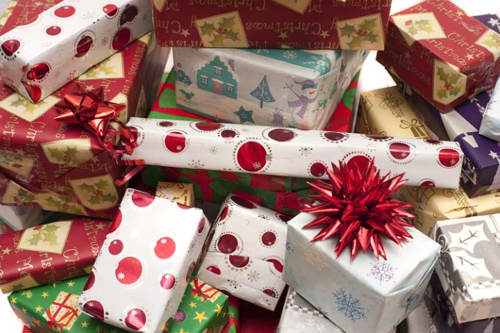 Pile of decorative colorful Christmas gifts in seasonal wrapping paper and bows in a full frame holiday background