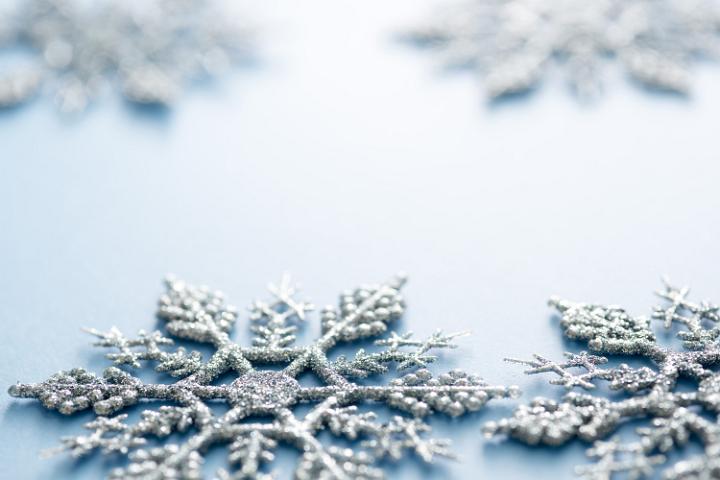 Christmas snowflake background in a low angle view across glittering Xmas ornaments with copy space