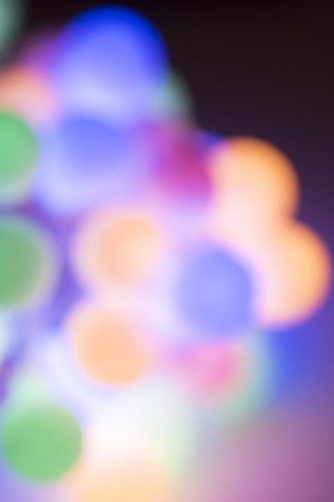 Defocused colorful Christmas lights background of multicolored round lights in a cluster with copy space for your holiday or seasonal message