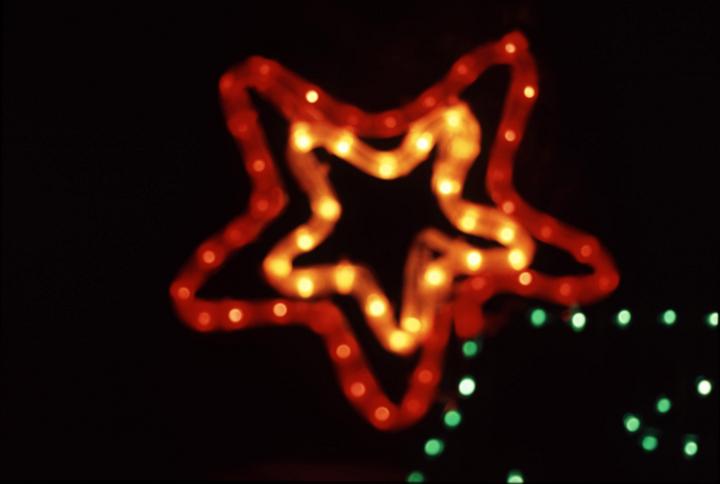 a festive illuminated decoration in the form af a christmas tree with star on top